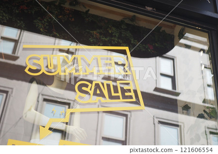 Large yellow Sale text letters on a glass wall obstruct a view inside the popular fashion store Large yellow Sale text letters on a glass wall obstruct a view inside the popular fashion store 121606554