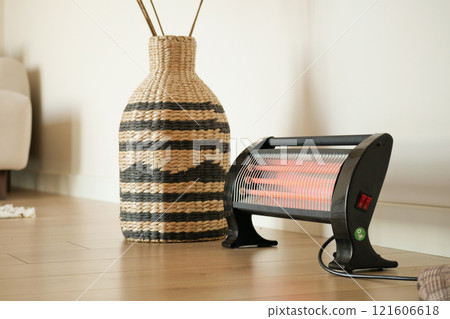 Modern electric infrared heater in living room, closeup Modern electric infrared heater in living room, closeup 121606618