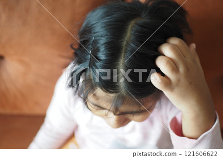 A Child with Curly Hair Engaged in Thought While Sitting on a Couch A Child with Curly Hair Engaged in Thought While Sitting on a Couch 121606622