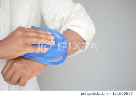 Person Applying Blue Ice Pack to Their Arm for Pain Relief or Injury Person Applying Blue Ice Pack to Their Arm for Pain Relief or Injury 121606637