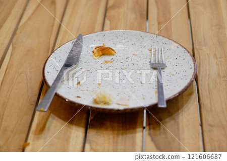 An empty dirty plate with a fork. 121606687