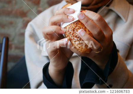 Enjoying a Savory Pastry in a Cozy Caf Setting 121606783
