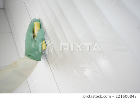 Cleaning Tiles with a Sponge and Gloves in a Stylish Bathroom for Optimal Hygiene 121606842