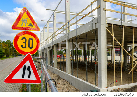 Unfinished concrete and metal structure building frame with traffic restriction warning signs Unfinished concrete and metal structure building frame with traffic restriction warning signs 121607149