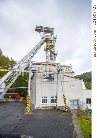 The mining tower in Jachymov, Czechia, reflects the region's rich history of mineral extraction. Surrounded by lush greenery, it stands as a testament to past industrial activities. The mining tower in Jachymov, Czechia, reflects the region's rich history of mineral extraction. Surrounded by lush greenery, it stands as a testament to past industrial activities. 121608428