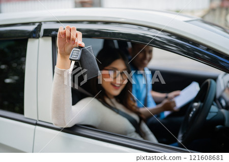 A Happy Young Woman Joyfully Celebrating Her New Car Purchase While Holding the Keys A Happy Young Woman Joyfully Celebrating Her New Car Purchase While Holding the Keys 121608681