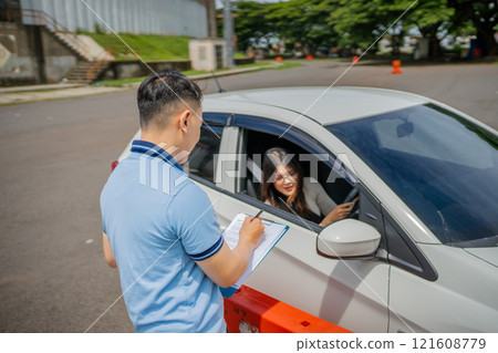 Driving Lesson in Progress The Instructor is Evaluating the Student Drivers Skills 121608779