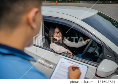 A Driving Test Assessment conducted between an Instructor and Student inside the Car A Driving Test Assessment conducted between an Instructor and Student inside the Car 121608784