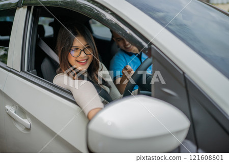 Joyful Drive: Smiling Woman in Car with Friend Enjoying a Relaxing Trip Joyful Drive: Smiling Woman in Car with Friend Enjoying a Relaxing Trip 121608801