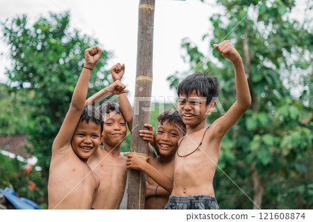 children are excited and laughing in the betel nut climbing competition children are excited and laughing in the betel nut climbing competition 121608874