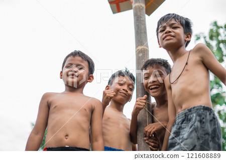 children smile at the camera under the pole of the betel nut children smile at the camera under the pole of the betel nut 121608889