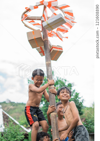 laughing children happily climbing during a betel nut climbing competition 121608890