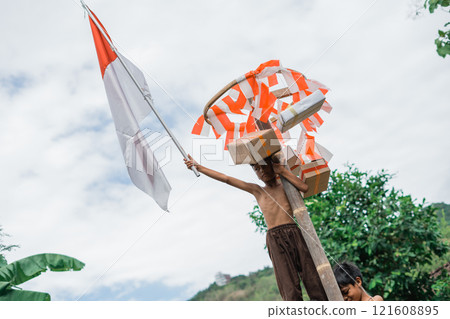 boy climbs and raises the Indonesian flag while winning the climbing competition boy climbs and raises the Indonesian flag while winning the climbing competition 121608895