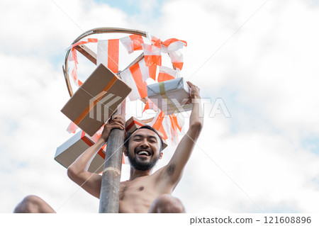 man is happy to get the prize of the pinang climbing competition 121608896