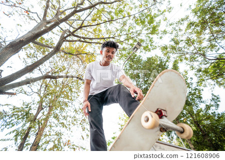 A Skateboarder Skillfully Performing Tricks at a Beautiful Scenic Park Location 121608906