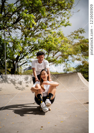 Experiencing a joyful skateboarding moment with friends in a sunny park setting Experiencing a joyful skateboarding moment with friends in a sunny park setting 121608909