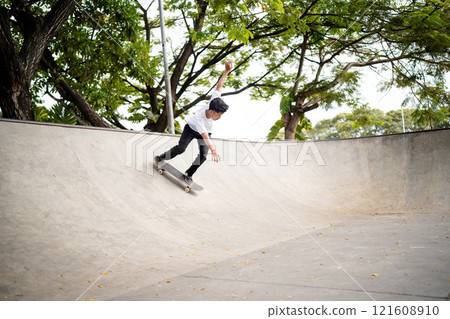 Skateboarder skillfully performing an array of exciting tricks in a modern skate park Skateboarder skillfully performing an array of exciting tricks in a modern skate park 121608910