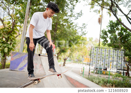 A Skateboarder Performing Exciting Tricks at a Vibrant Outdoor Skatepark 121608920