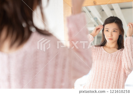 Woman looking in the mirror 121610258
