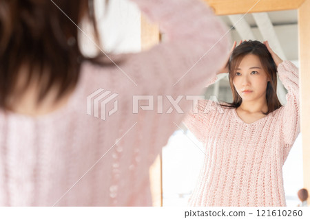 Woman looking in the mirror 121610260