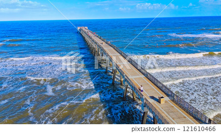 A Beautiful Scenic Wooden Pier Stretching Out Over the Ocean Waves A Beautiful Scenic Wooden Pier Stretching Out Over the Ocean Waves 121610466