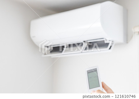 White air conditioner and hand operating the remote control White air conditioner and hand operating the remote control 121610746