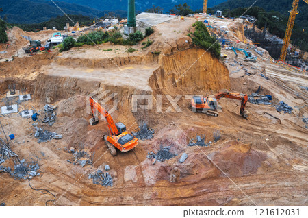 construction site with excavators digging a pit for foundation of a building under construction 121612031