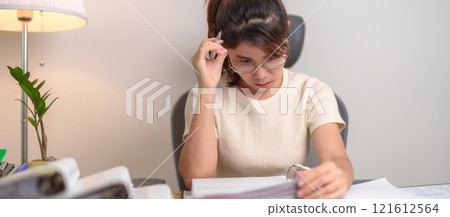 Asian woman having Tired and Stressed while working, female businesswoman having headache and Migraine at office, Exhausted woman with document folder stack at home late night. Overworked and Overtime Asian woman having Tired and Stressed while working, female businesswoman having headache and Migraine at office, Exhausted woman with document folder stack at home late night. Overworked and Overtime 121612564