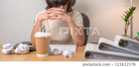 Asian woman having Tired and Stressed while working, female businesswoman having headache and Migraine at office, Exhausted woman with document folder stack at home late night. Overworked and Overtime Asian woman having Tired and Stressed while working, female businesswoman having headache and Migraine at office, Exhausted woman with document folder stack at home late night. Overworked and Overtime 121612576