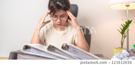 female businesswoman having headache and Migraine at office, Asian woman having Tired and Stressed while working, Exhausted woman with document folder stack at home late night. Overworked and Overtime 121612656