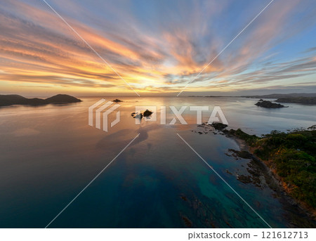 Cinematic drone shot of a beautiful sunrise over rocky islands Cinematic drone shot of a beautiful sunrise over rocky islands 121612713