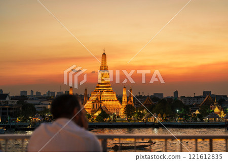 Wat Arun Temple in sunset, Tourists enjoy the view to Temple of Dawn near Chao Phraya river. Take photo from rooftop bar. Landmark and Travel destination in Bangkok, Thailand and Southeast Asia 121612835