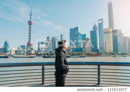 man traveler visiting in Shanghai, China. male Tourist sightseeing Shanghai view of Lujiazui in The Bund of Shanghai. landmark and popular for tourism attractions. Vacation concept 121613057