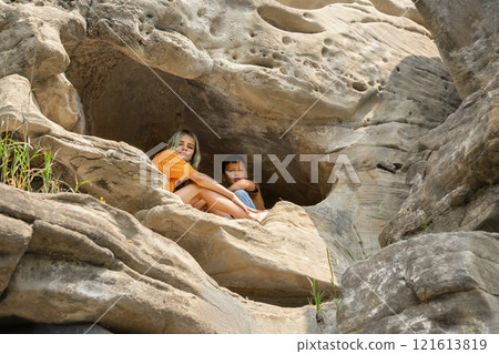 Two friends escaped to a cave on the cliff to find peace. Two friends escaped to a cave on the cliff to find peace. 121613819