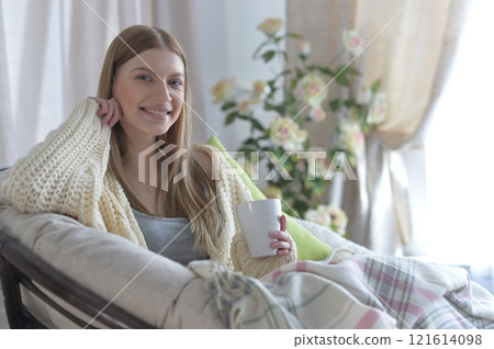 Portrait of young woman in pajamas on bed with fluffy plaid Portrait of young woman in pajamas on bed with fluffy plaid 121614098