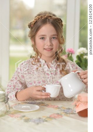 Smiling little girl holding big cup of tea 121614100