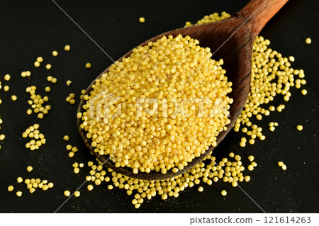 Millet groats in a wooden spoon. 121614263