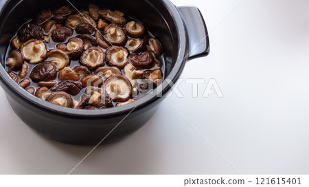 Black pot and dried shiitake mushrooms soaked in water - Preparation image material - 16:9 121615401