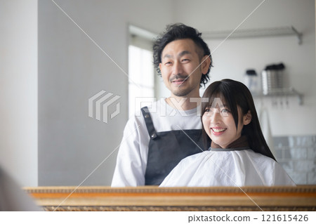 Cutting and hair care at a beauty salon: Customer and hairdresser, upper body image Cutting and hair care at a beauty salon: Customer and hairdresser, upper body image 121615426