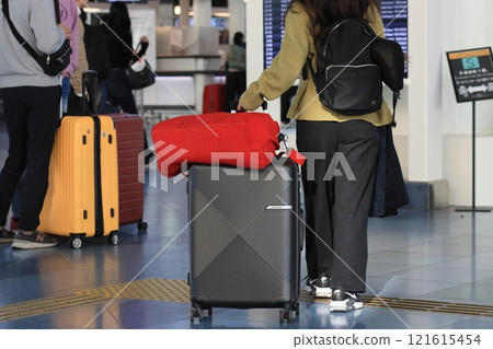 Travelers pulling suitcases at the airport Travelers moving around with luggage on carts 121615454