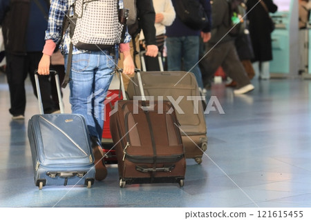 一名旅客在機場拉著行李箱 一名旅客將行李裝入手推車並移動 一名旅客在機場拉著行李箱 一名旅客將行李裝入手推車並移動 121615455