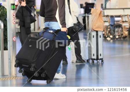一名旅客在機場拉著行李箱 一名旅客將行李裝入手推車並移動 一名旅客在機場拉著行李箱 一名旅客將行李裝入手推車並移動 121615456