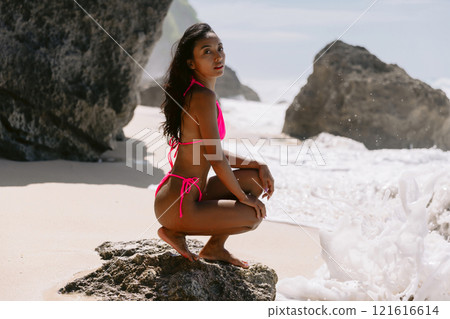 Asian woman in bikini at tropical beach. Pretty girl at ocean coastline Asian woman in bikini at tropical beach. Pretty girl at ocean coastline 121616614