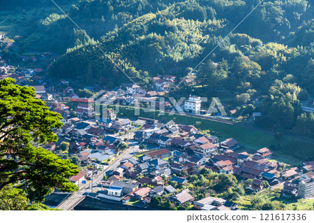 [Japan's 100 Famous Castles] A local train on the Yamaguchi Line running through the Tsuwano Basin as seen from Tsuwano Castle on an autumn morning 4 Tsuwano Town, Kashima Prefecture 121617336