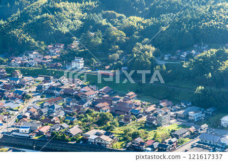 [Japan's 100 Famous Castles] A local train on the Yamaguchi Line running through the Tsuwano Basin as seen from Tsuwano Castle on an autumn morning 3 Tsuwano Town, Kashima Prefecture 121617337