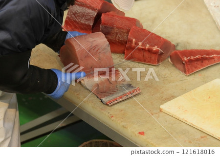 Raw tuna being cut into pieces Raw tuna being cut into pieces 121618016