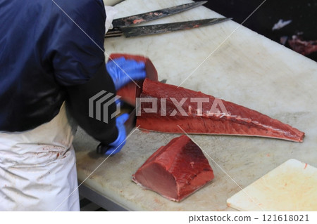 Raw tuna being cut into pieces Raw tuna being cut into pieces 121618021