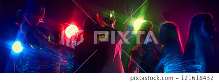 Banner. Friends raise glasses high, celebrating under neon lights, dance floor alive with rhythm and joyful energy. 121618432