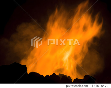 Intense orange flames and smoke rise against a dark background, depicting the burning of fossil fuels like coal or oil. Close-up detail highlights the heat, energy, and pollution generated by this co Intense orange flames and smoke rise against a dark background, depicting the burning of fossil fuels like coal or oil. Close-up detail highlights the heat, energy, and pollution generated by this co 121618479