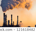 Industrial pollution. Silhouetted refinery chimneys and smoke stacks billowing dark, grey and orange smoke against a vibrant sunset sky. Air pollution from fossil fuel burning. Climate change, global  121618482